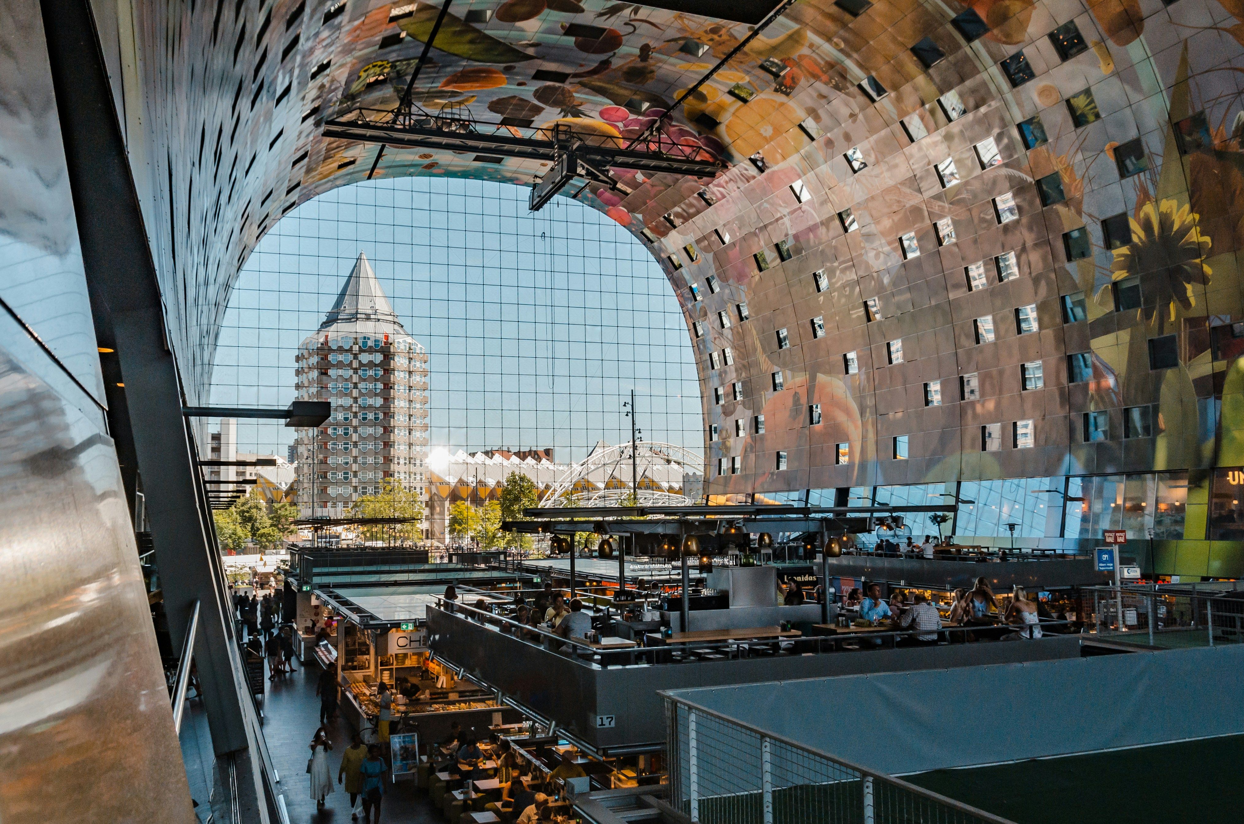 The inside of the market hall in Rotterdam with a huge glass window in the back.